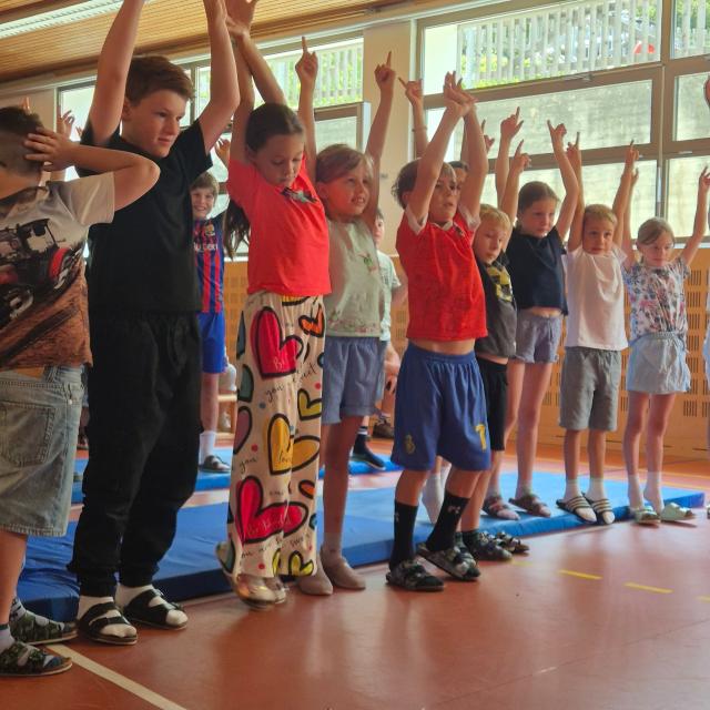 Volksschulkinder beim Mitmachkonzert, alle Hände nach oben.